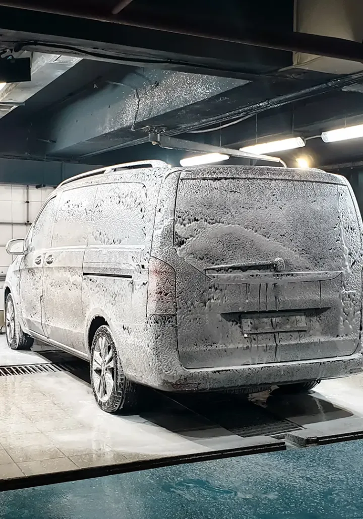 Detailed exterior wash and wax of a minivan, showcasing the vehicle's polished finish and clean lines.