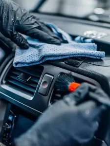 Interior of a sedan during a detailed cleaning session, focusing on upholstery and dashboard restoration.